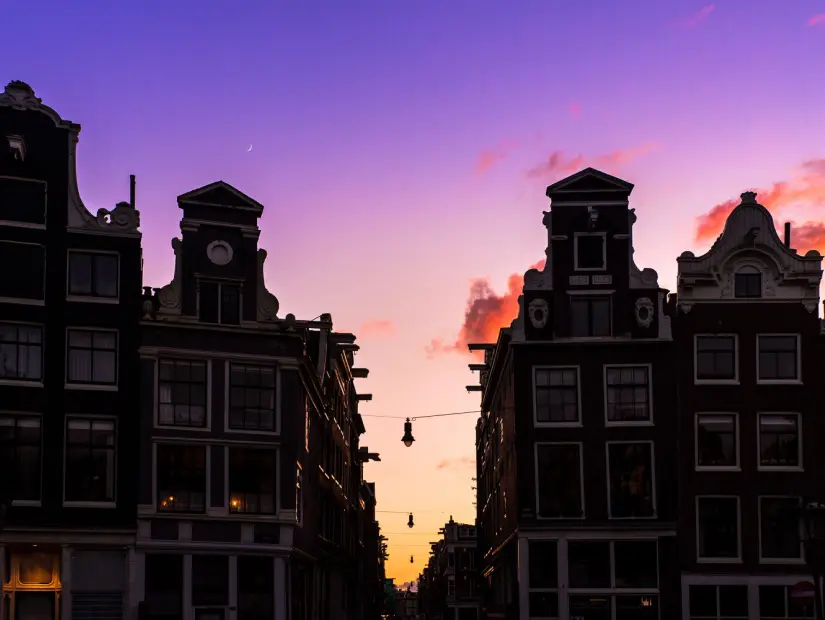 Gün batımında Hollanda'nın Amsterdam kentindeki küçük dokuz sokaktaki kanal evleri