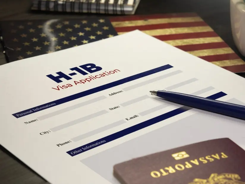 Pasaportlu bir masada ABD H-1B vize başvurusu