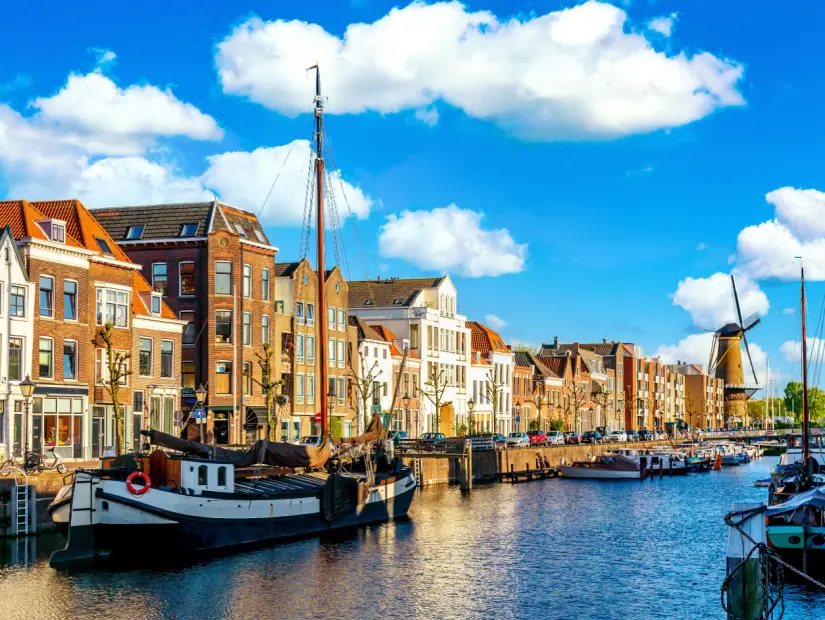 Güneşli bir yaz günü Hollanda'da yabani değirmen ve tekne evlerin bulunduğu eski tarihi bölge Delfshaven. 