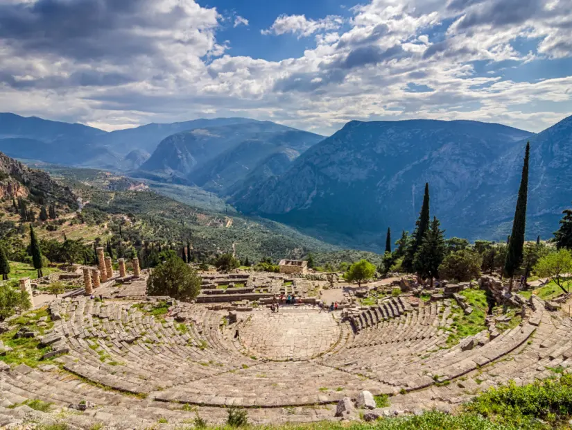 Delphi Antik Tiyatrosu bulutlu gökyüzü ile güneşli bir günde panoramik manzara