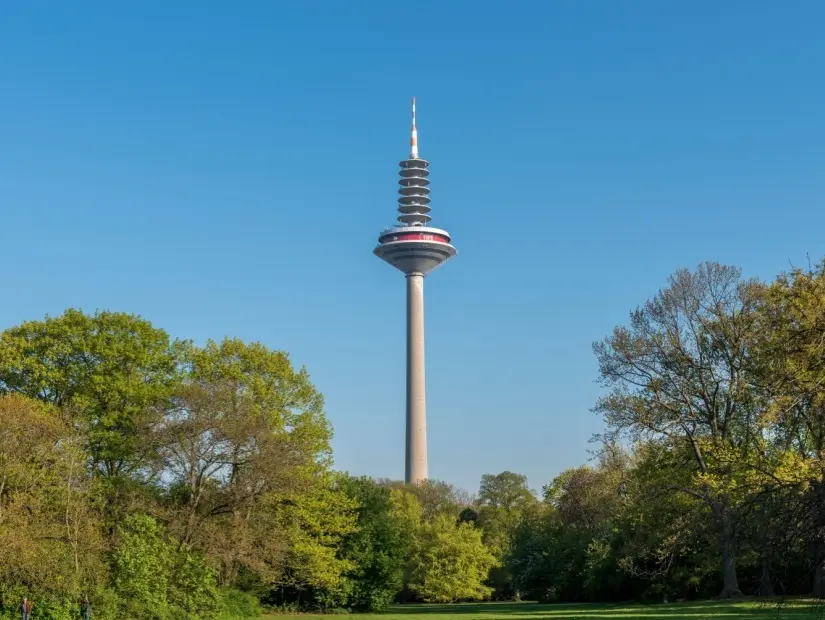 Bulutsuz mavi gökyüzünün ve ön planda Grüneburgpark'ın önünde "Ginnheimer Spargel" adı verilen Frankfurt am Main'deki radyo kulesi