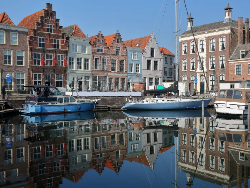  Goes limanına demirlemiş tarihi ortaçağ evlerinin ve yelkenli teknelerin yansımaları, Goes, Zeeland, Hollanda