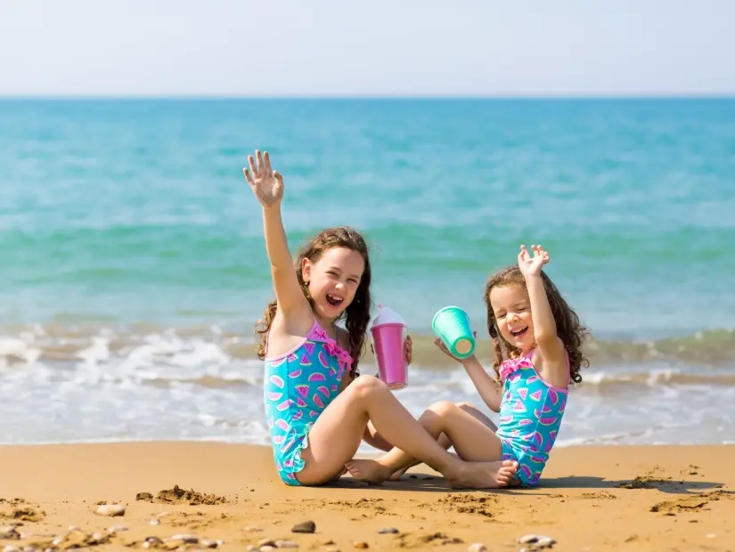 iki kız kardeş tatil yaparken deniz arkaplanda