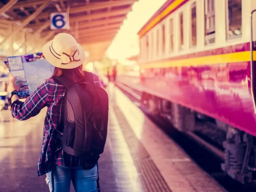 Asyalı kadın gezginler, bagaj ve büyük sırt çantaları ve haritayla tren istasyonu yolculuğunda bekliyor