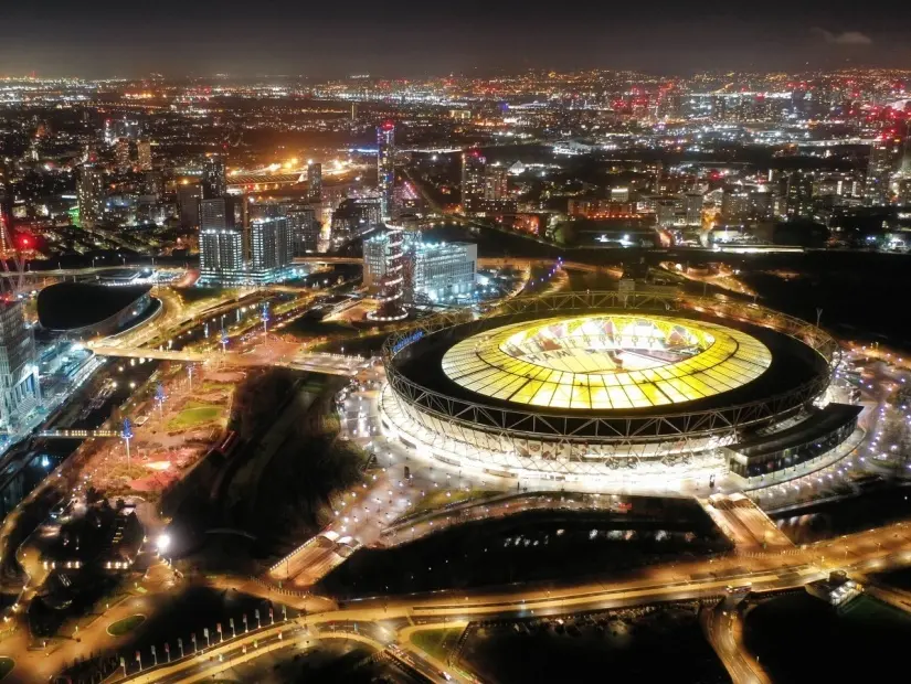 Londra, Birleşik Krallık'ta Queen Elisabeth parkındaki ikonik ışıklı Londra Stadyumu'nun havadan drone gece çekimi