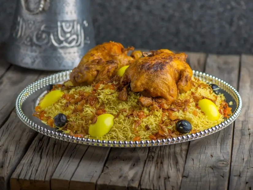 Tavuk Machboos biryani ahşap masa arka planında servis ediliyor.