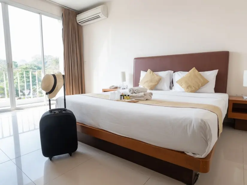 Otel yatak odasında yatağın üzerinde düzenlenmiş otel olanakları