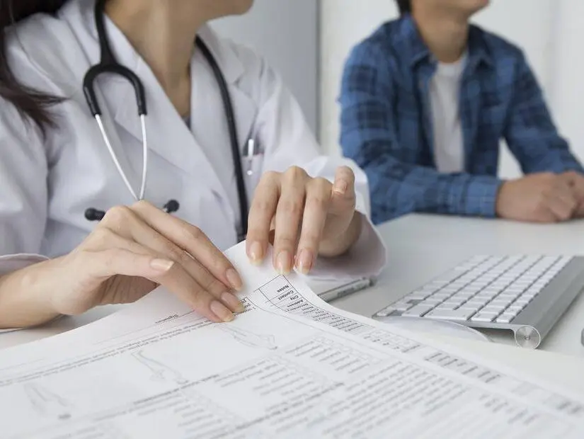 doktor tahlil sonuçlarını kontrol ediyor