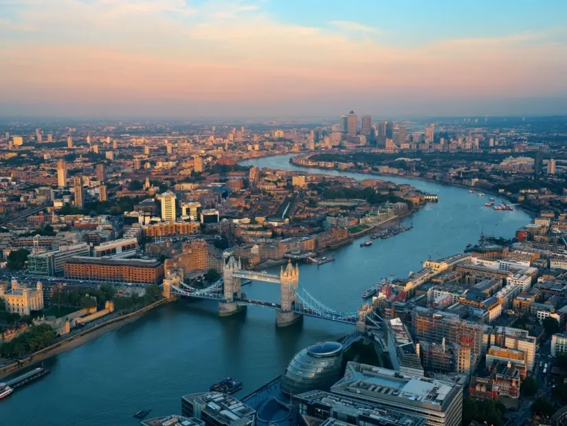 Şehir mimarileri ve Thames Nehri ile gün batımında Londra çatı manzaralı panorama.
