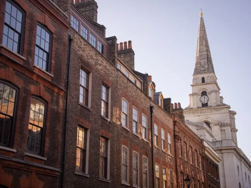 Londra'nın Whitechapel semtindeki tarihi bina, sağ köşede bir kilisenin kulesi görünümü